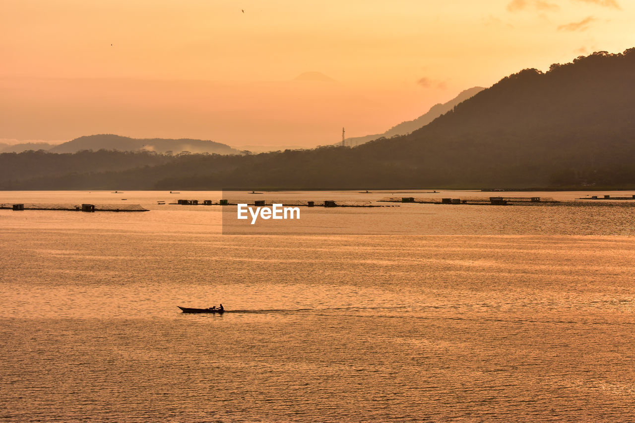 Scenic view of lake against orange sky