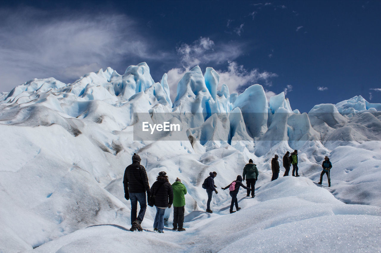 PEOPLE SKIING ON SNOWCAPPED MOUNTAINS