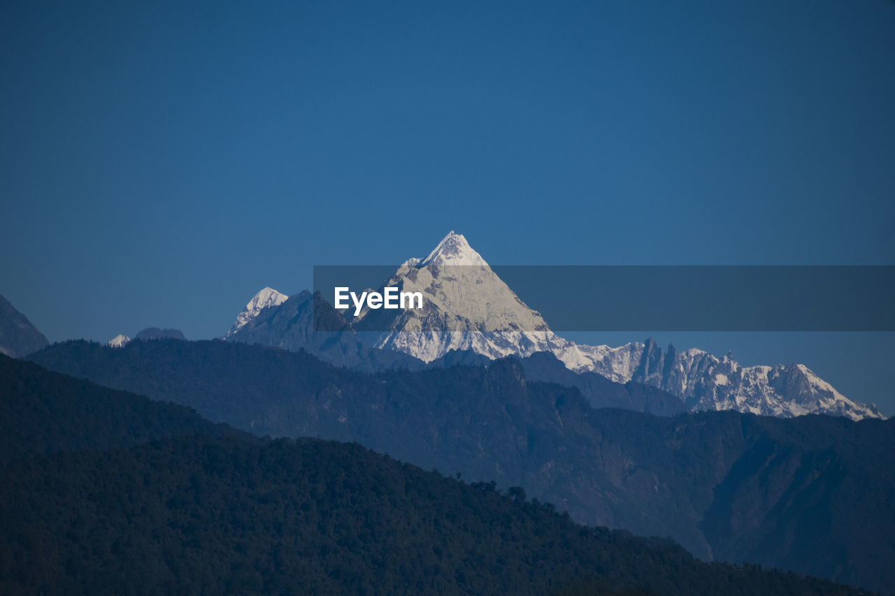 Scenic view of snowcapped mountains against clear sky