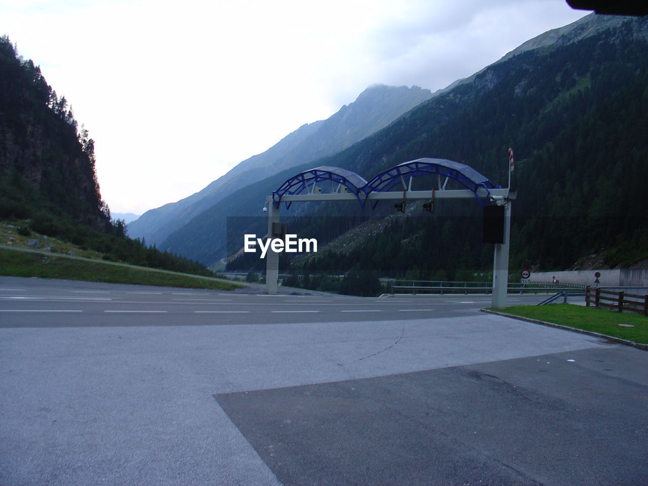 VIEW OF EMPTY ROAD WITH MOUNTAINS IN BACKGROUND