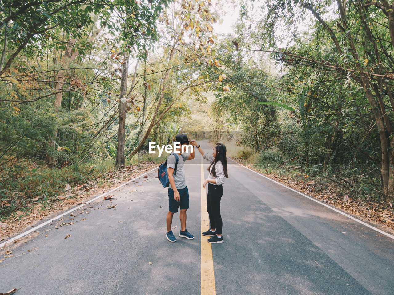 REAR VIEW OF WOMEN WALKING ON ROAD