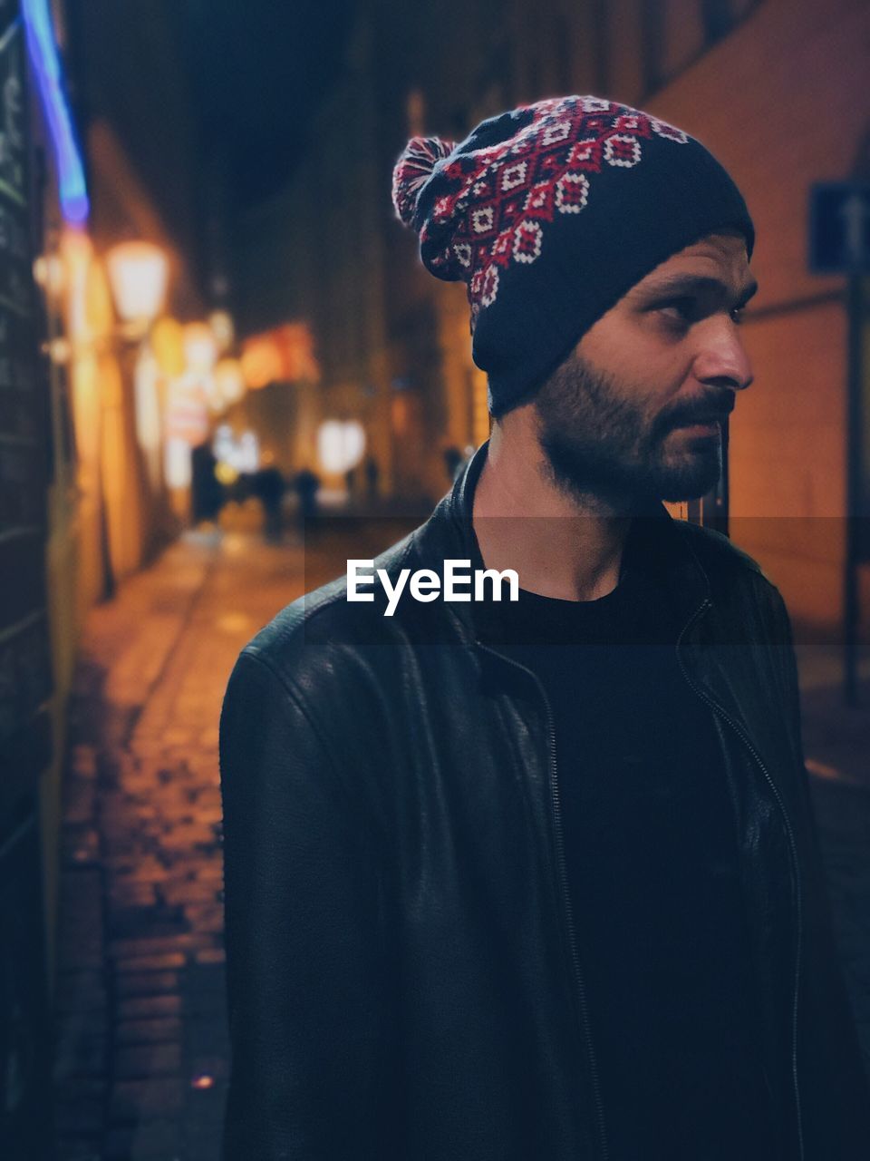 Young man looking away outdoors at night