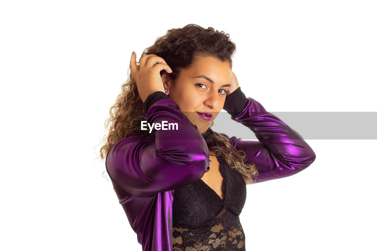 PORTRAIT OF YOUNG WOMAN LOOKING UP AGAINST WHITE BACKGROUND