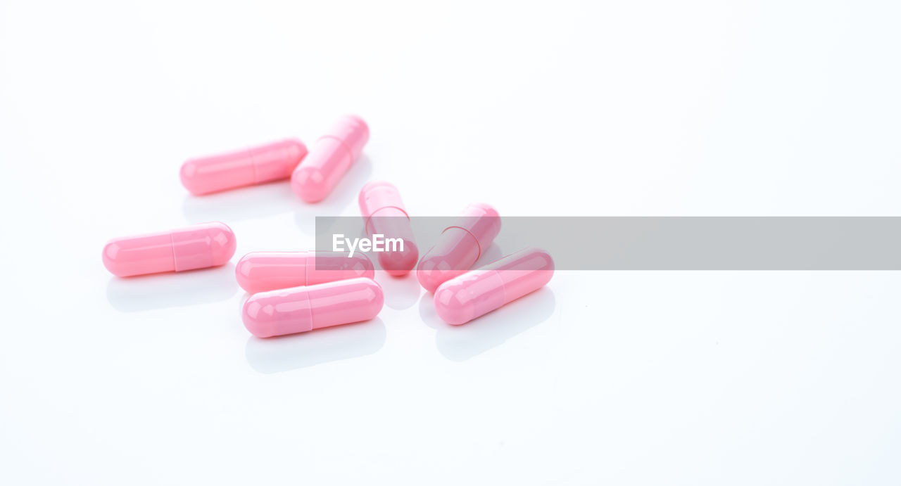 Pink capsule pills on white background. pharmaceutical industry. vitamins, minerals, and supplement