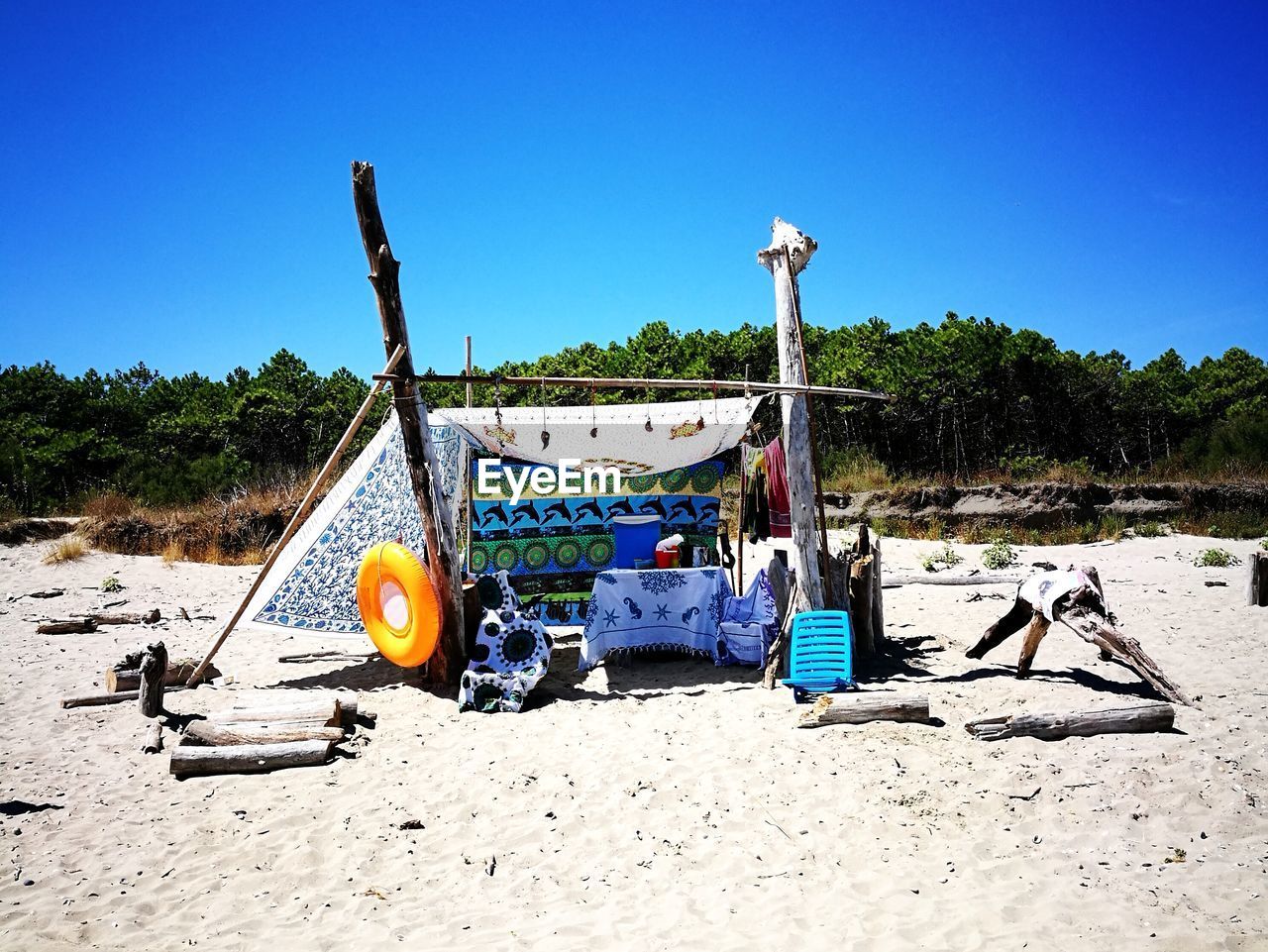 DECK CHAIRS ON SHORE AGAINST CLEAR BLUE SKY