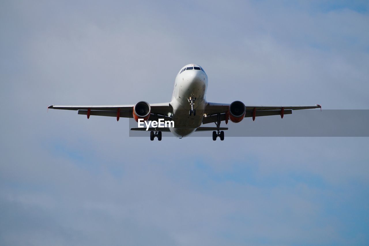 Low angle view of airplane flying against sky