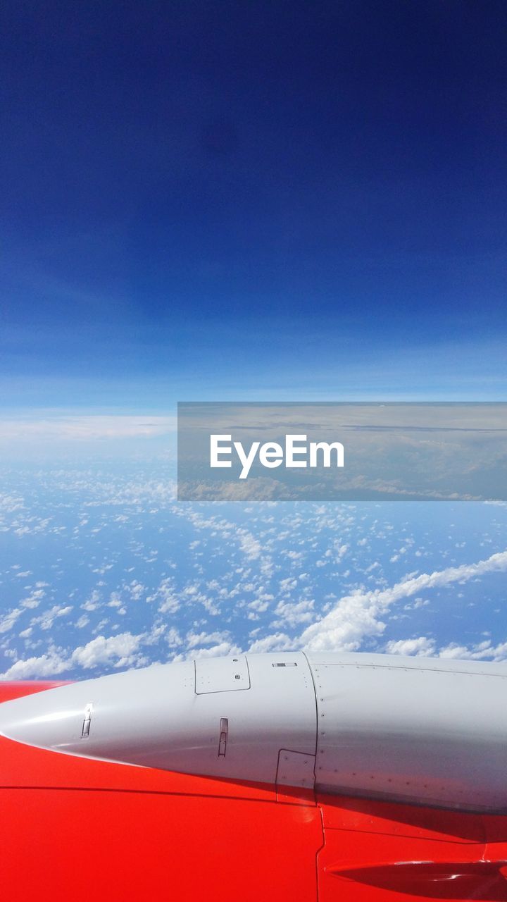 Cropped image of airplane flying over clouds