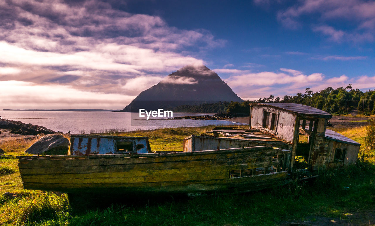 Built structure on landscape against dramatic sky