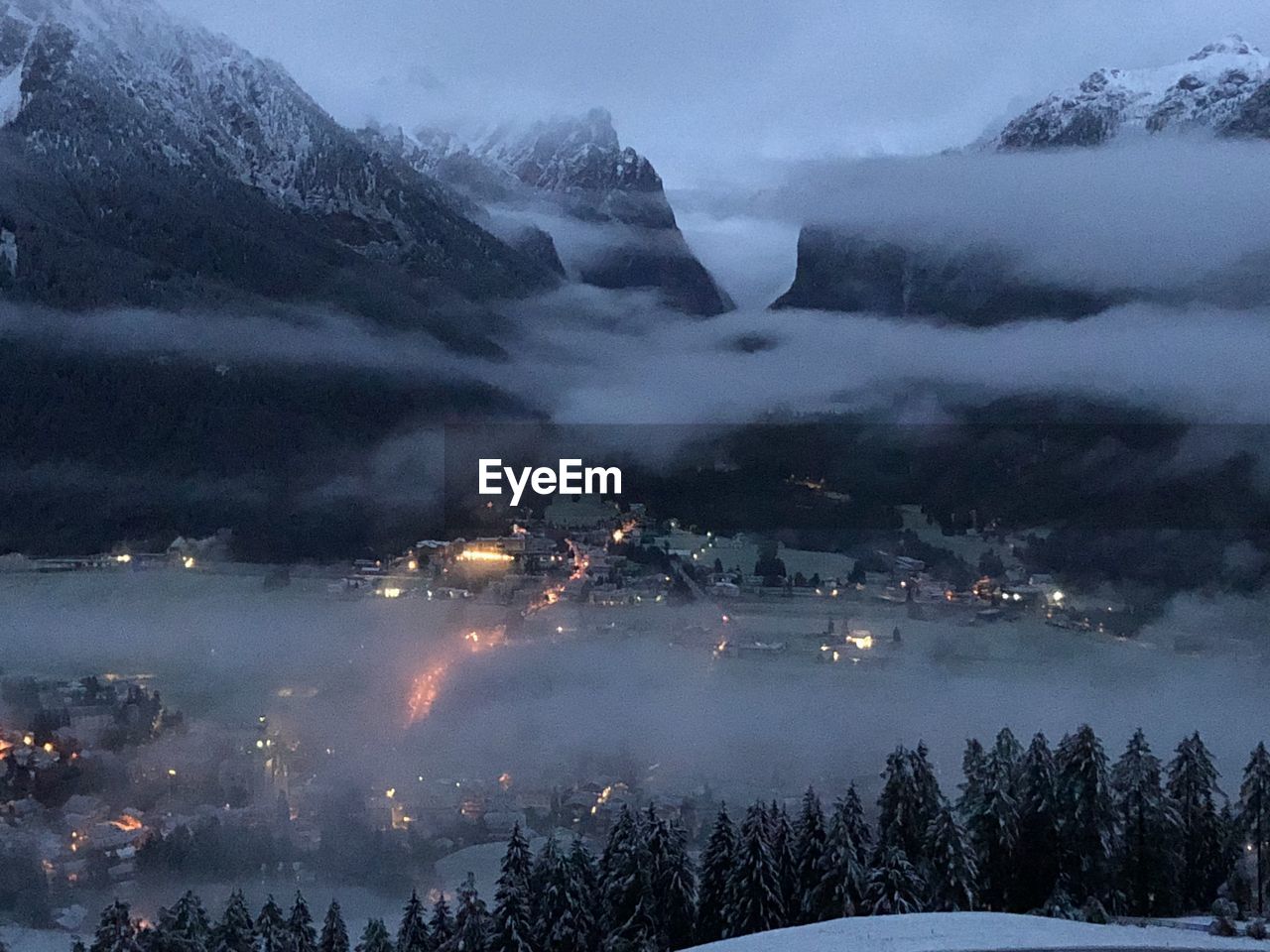 AERIAL VIEW OF ILLUMINATED SNOWCAPPED MOUNTAIN AGAINST SKY