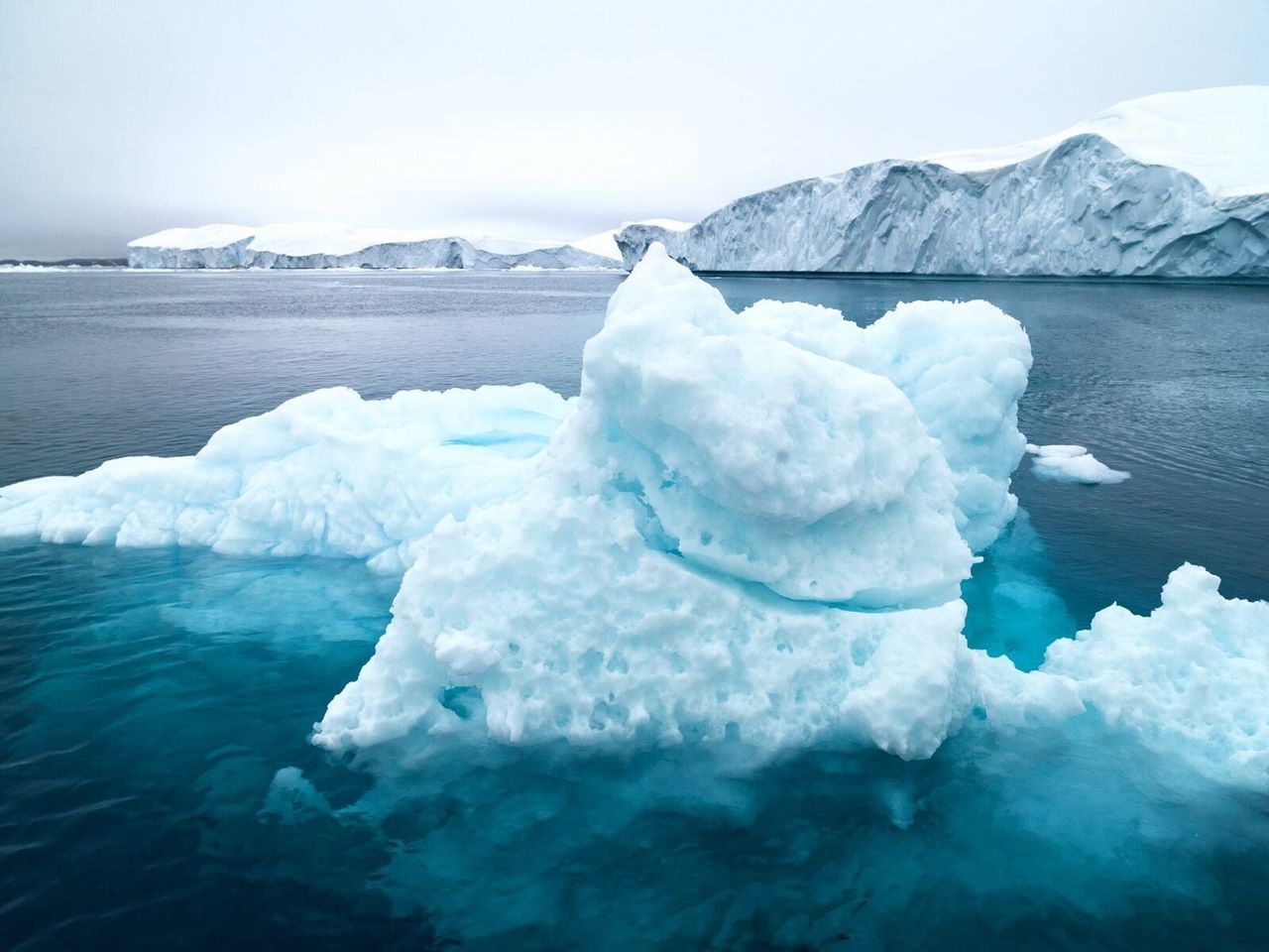 Glacier on frozen lake against sky