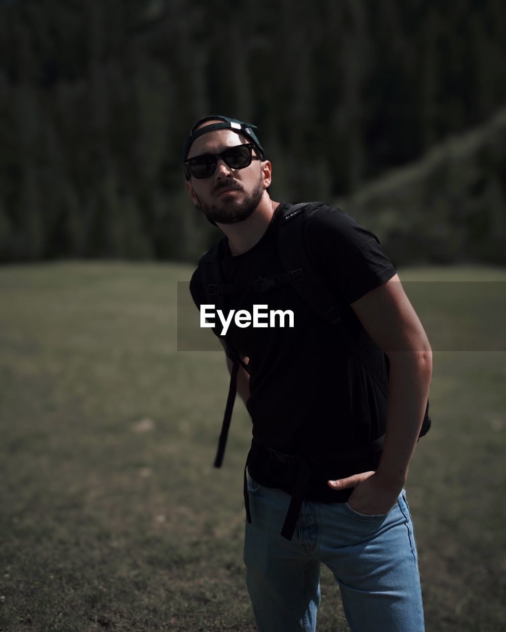YOUNG MAN WEARING SUNGLASSES STANDING ON LAND