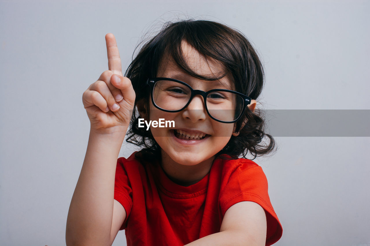 Portrait of smiling boy in eyeglasses on white background