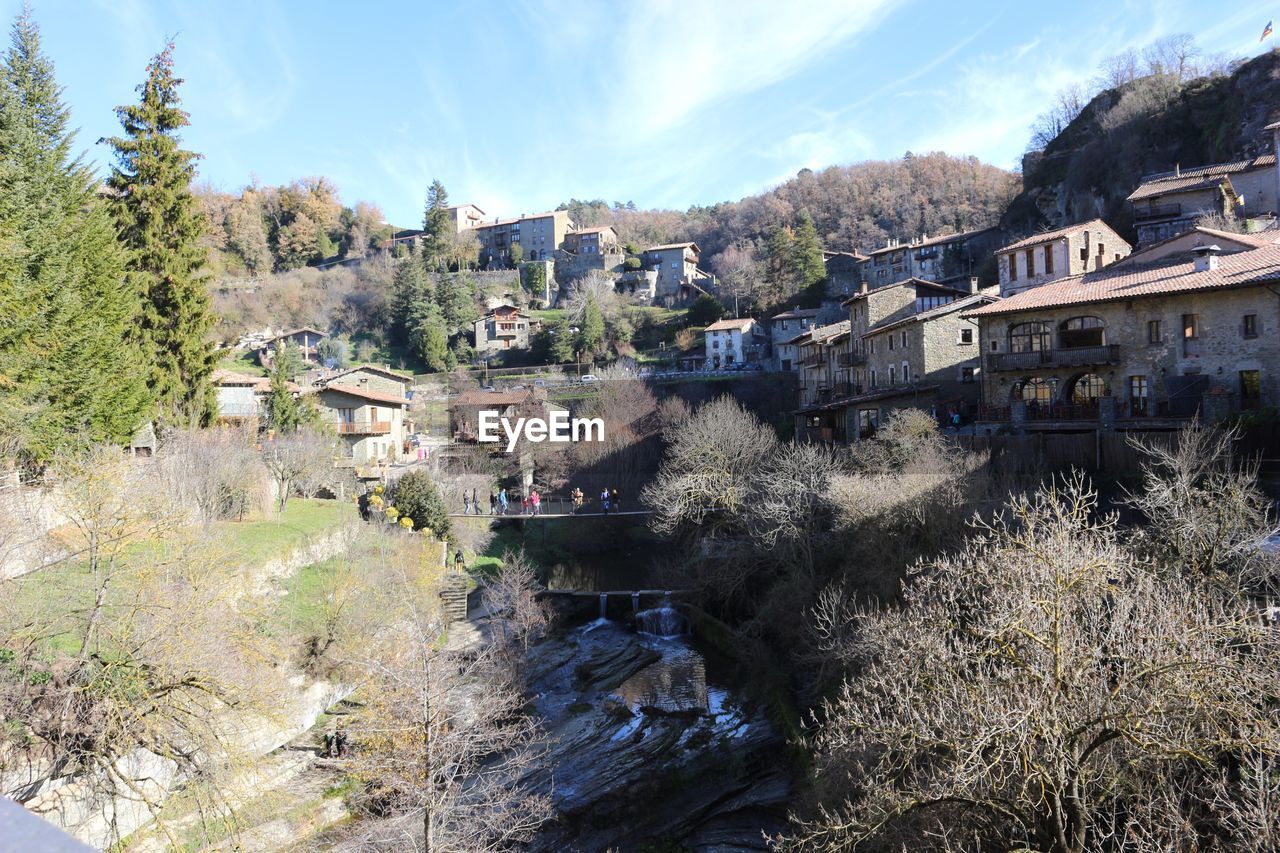 HIGH ANGLE VIEW OF BUILT STRUCTURES AGAINST TREES