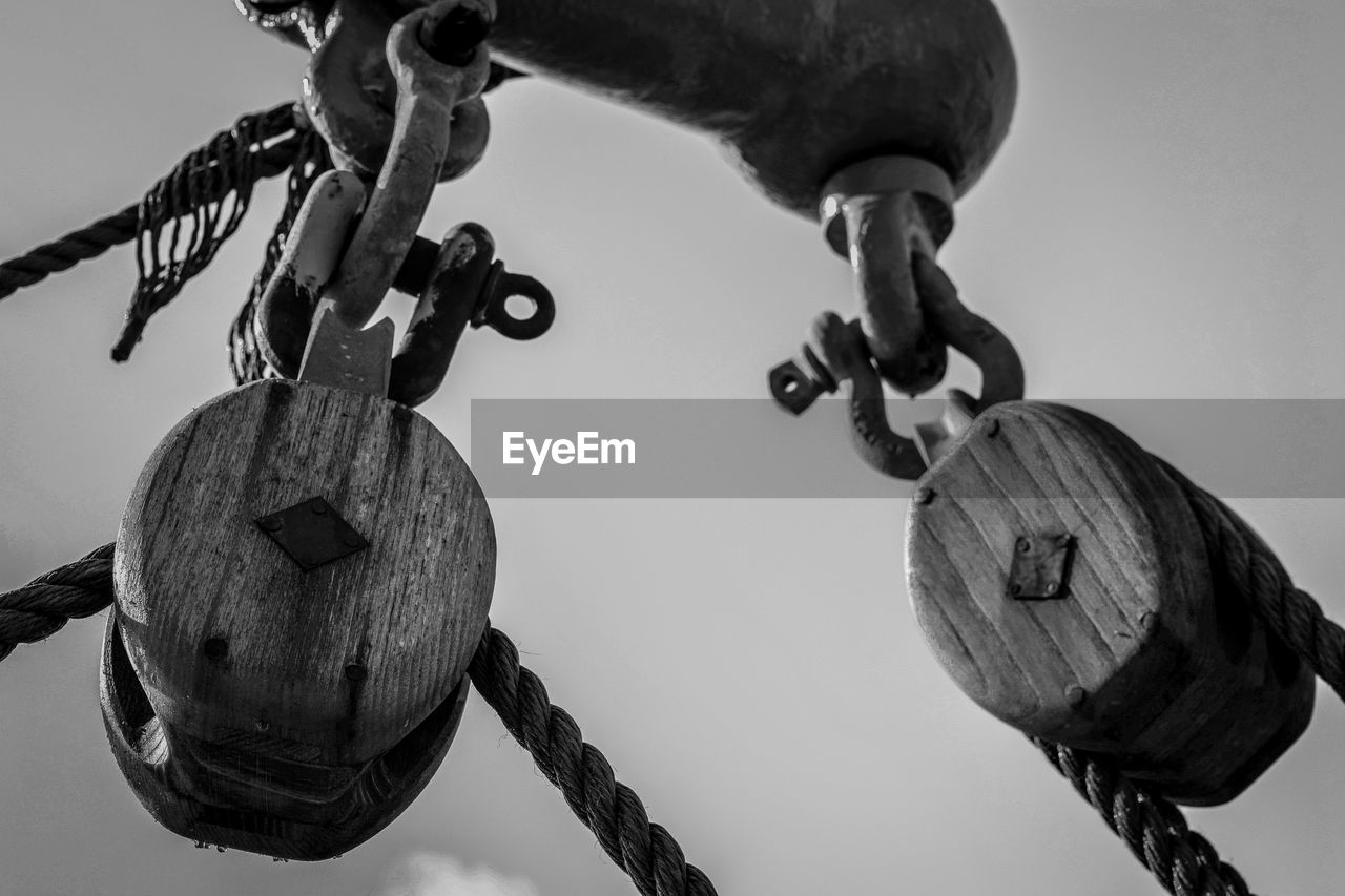 Low angle view of ropes in pulley against sky