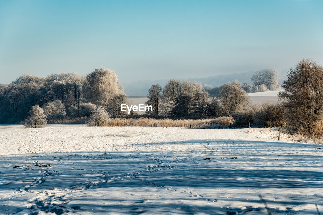 SNOW COVERED LANDSCAPE AGAINST SKY