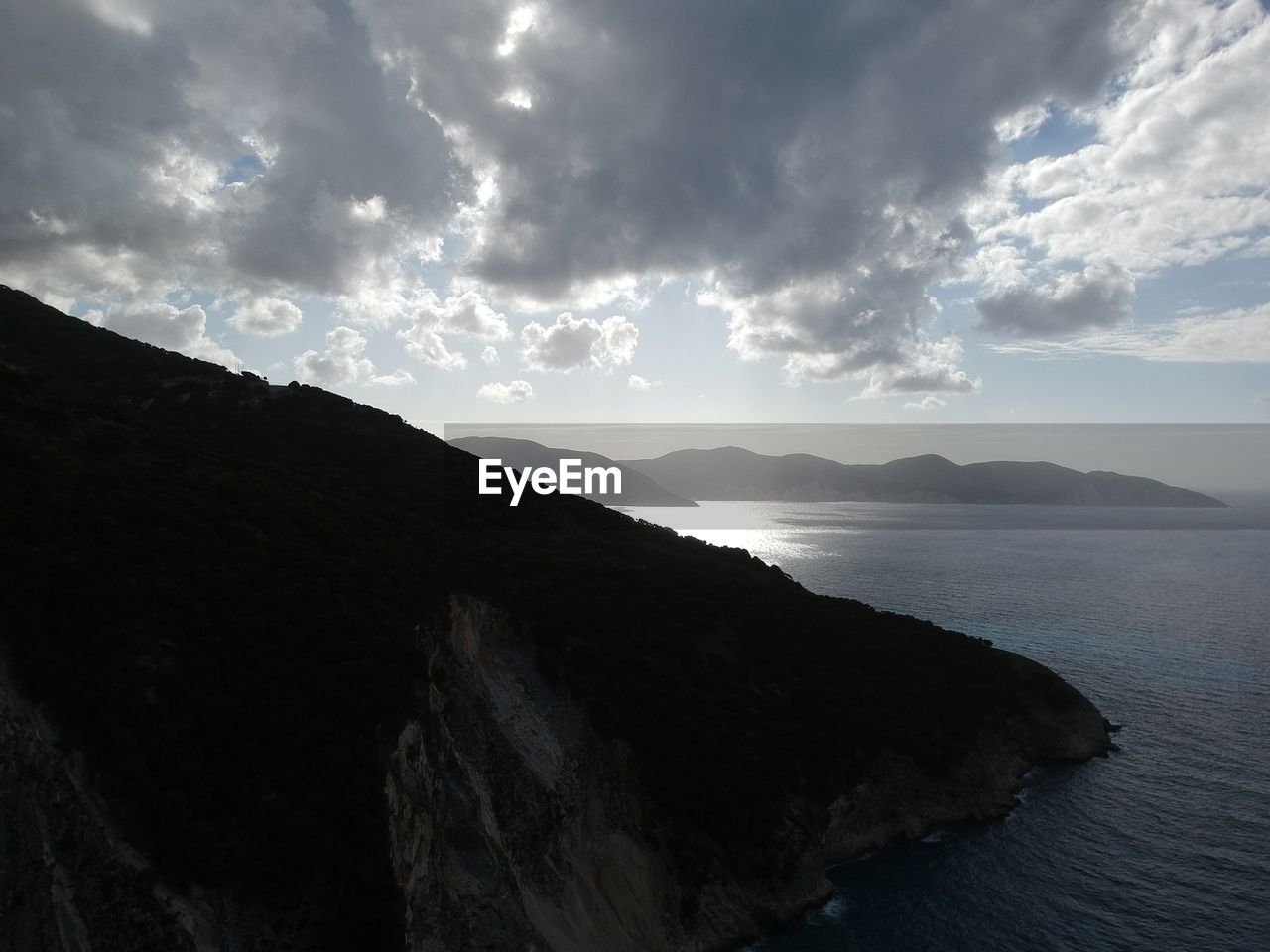 Scenic view of sea and mountains against sky