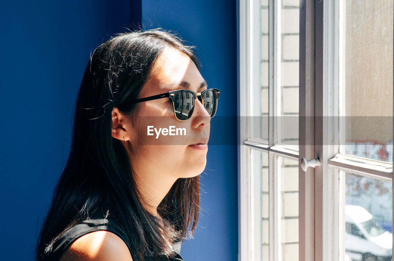 Beautiful woman looking through window