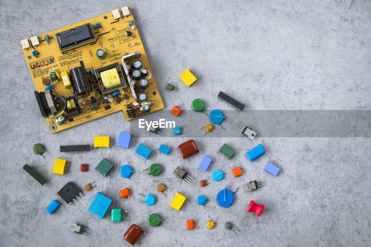 high angle view, gray, large group of objects, multi colored, no people, toy, yellow, directly above, gray background, indoors, equipment, studio shot, still life