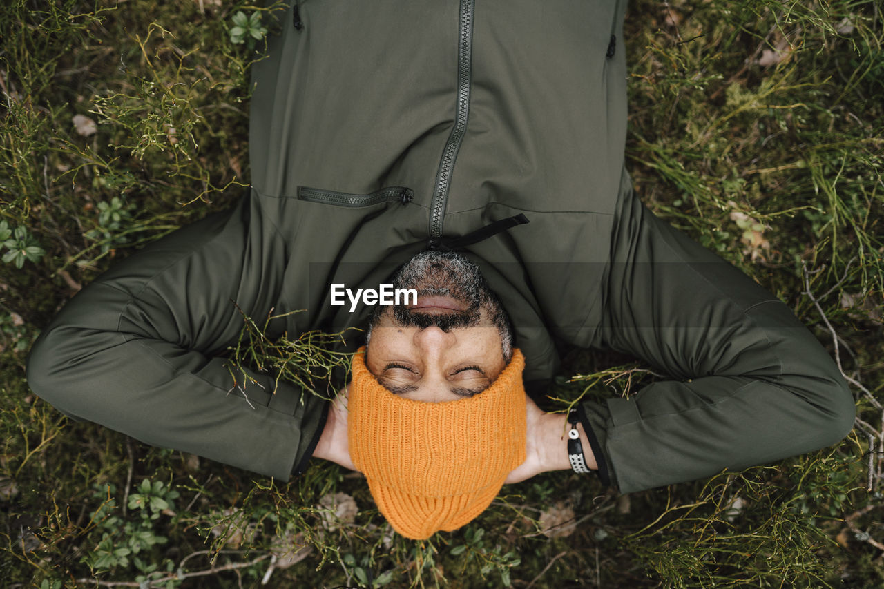 Directly above shot of man lying down on land in forest