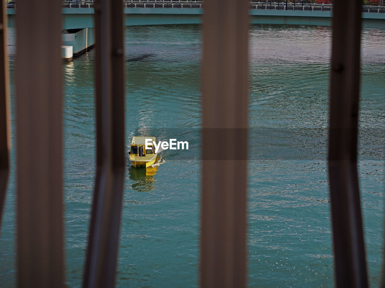 Far distance of a yellow taxi boat in the green turquoise color ocean. 