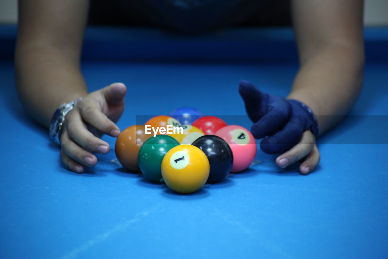 Close-up of person playing with balls on pool table