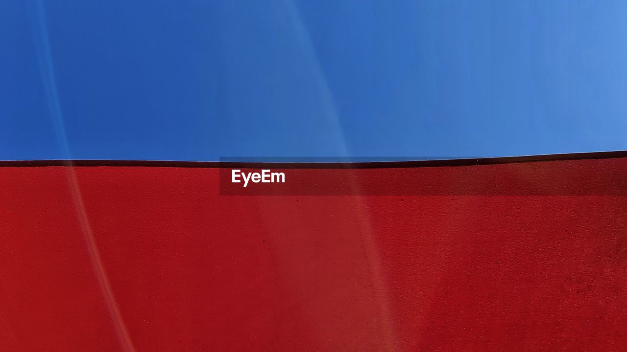 LOW ANGLE VIEW OF WALL AGAINST BLUE SKY