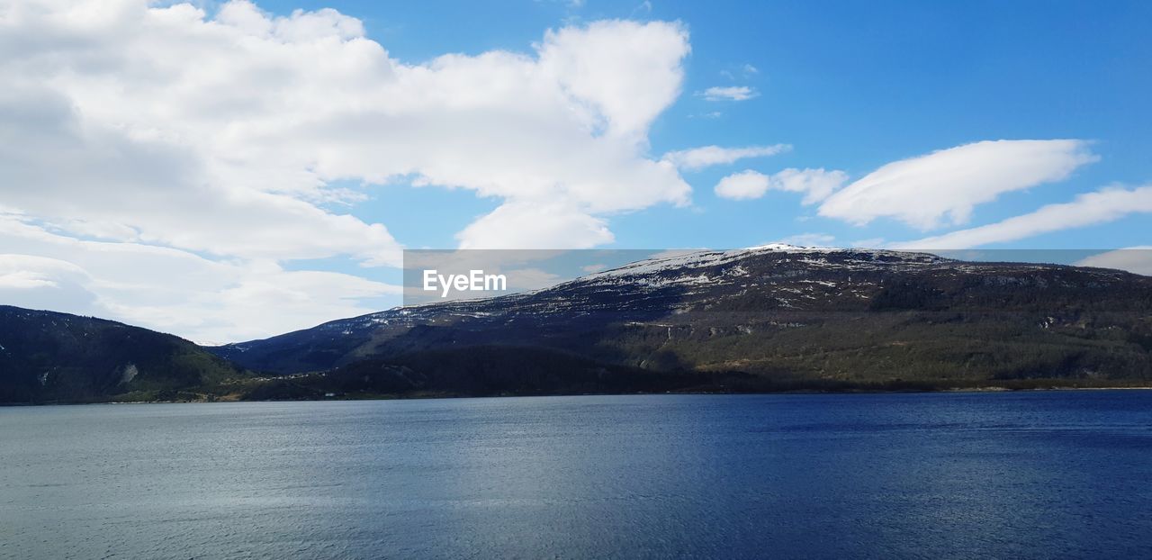 Scenic view of sea and mountains against sky