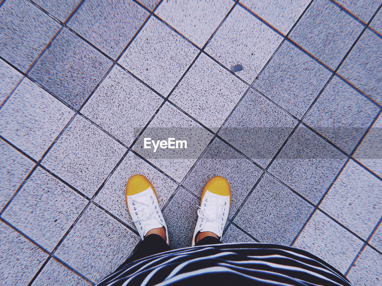 Low section of woman standing on tiled floor