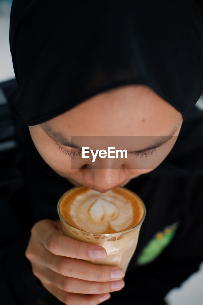 Close-up of woman holding coffee latte