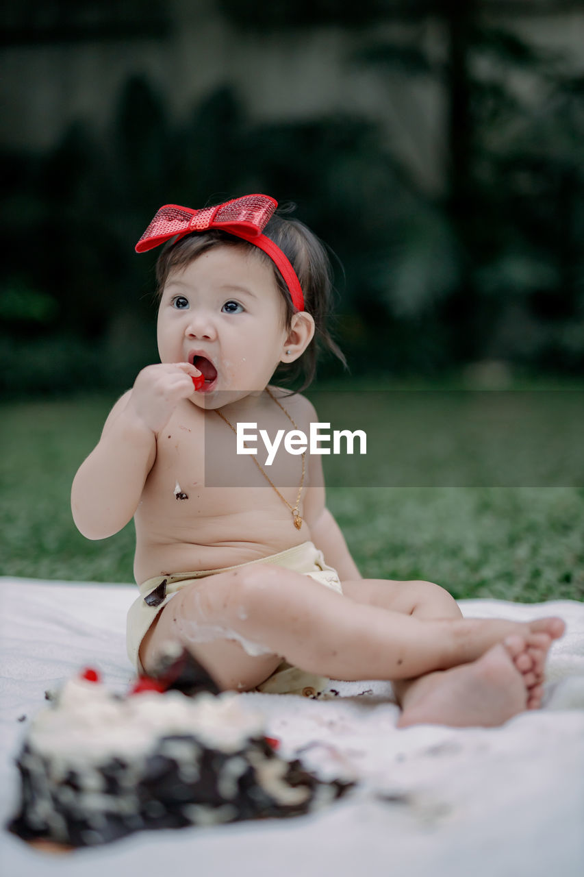 Portrait of cute baby girl eating cherry