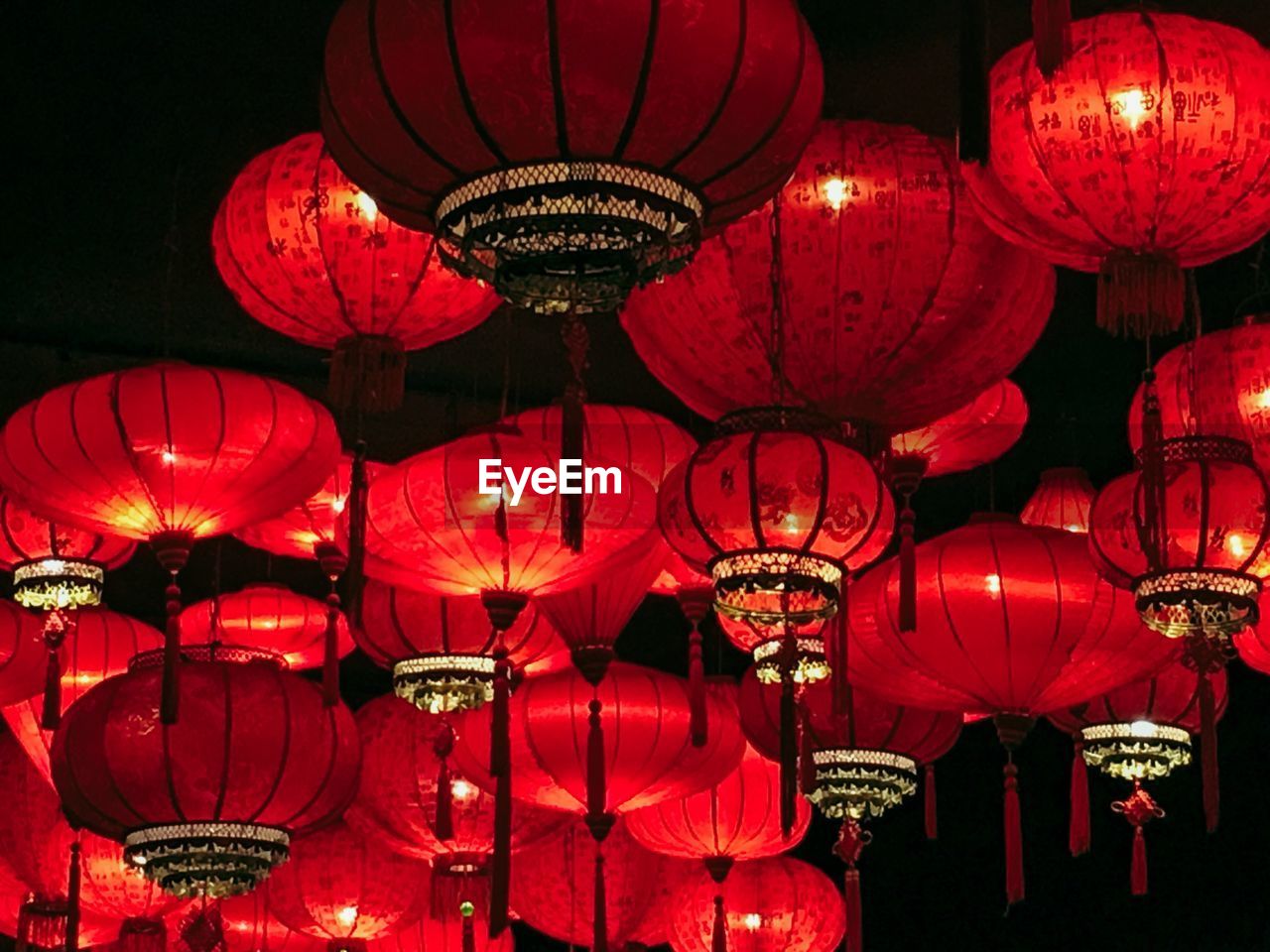 LOW ANGLE VIEW OF ILLUMINATED LANTERNS HANGING IN NIGHT