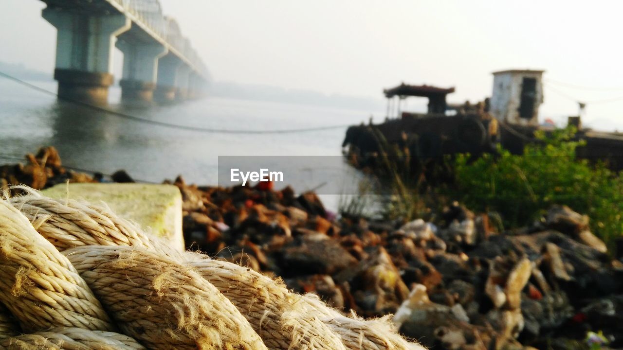 Close-up of rope at shore against sky