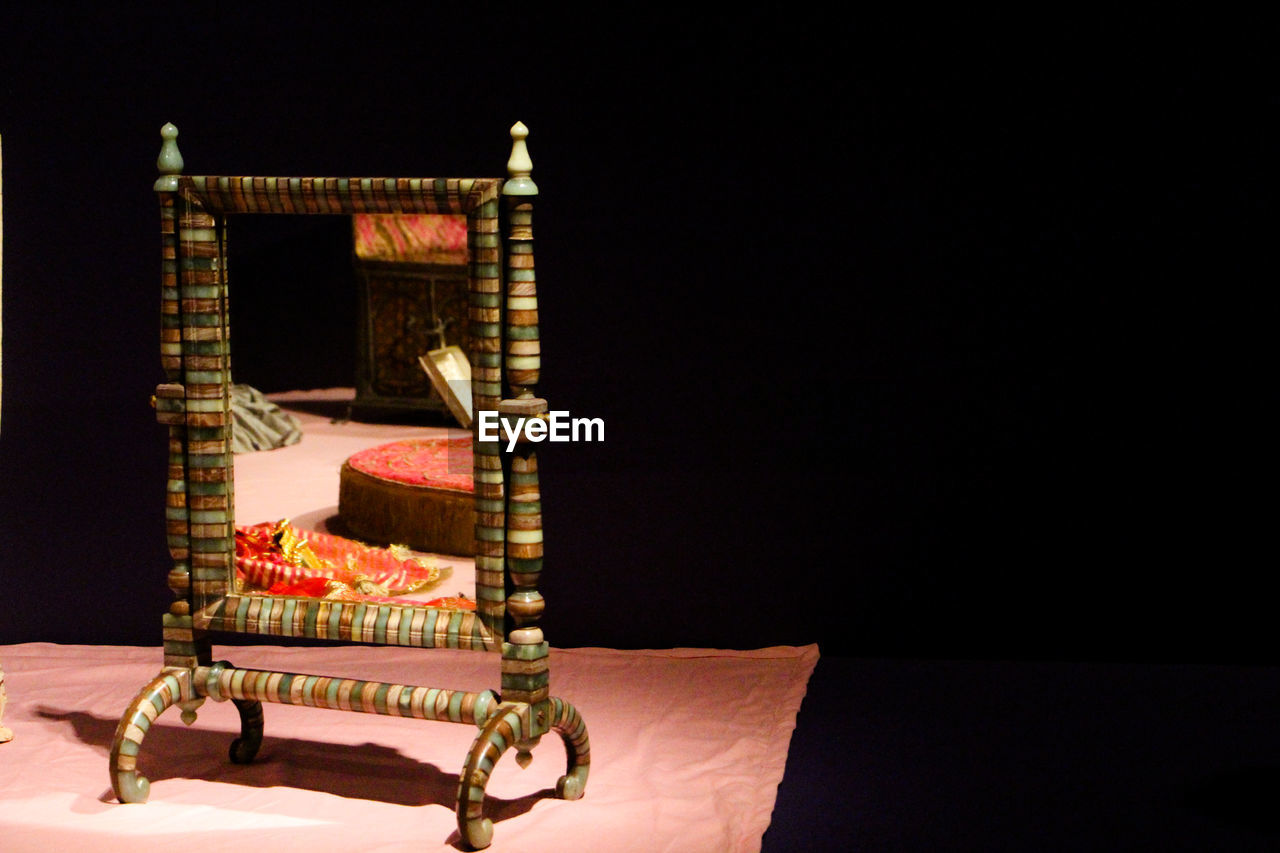 CLOSE-UP OF ILLUMINATED CANDLES ON TABLE AGAINST BUILDING