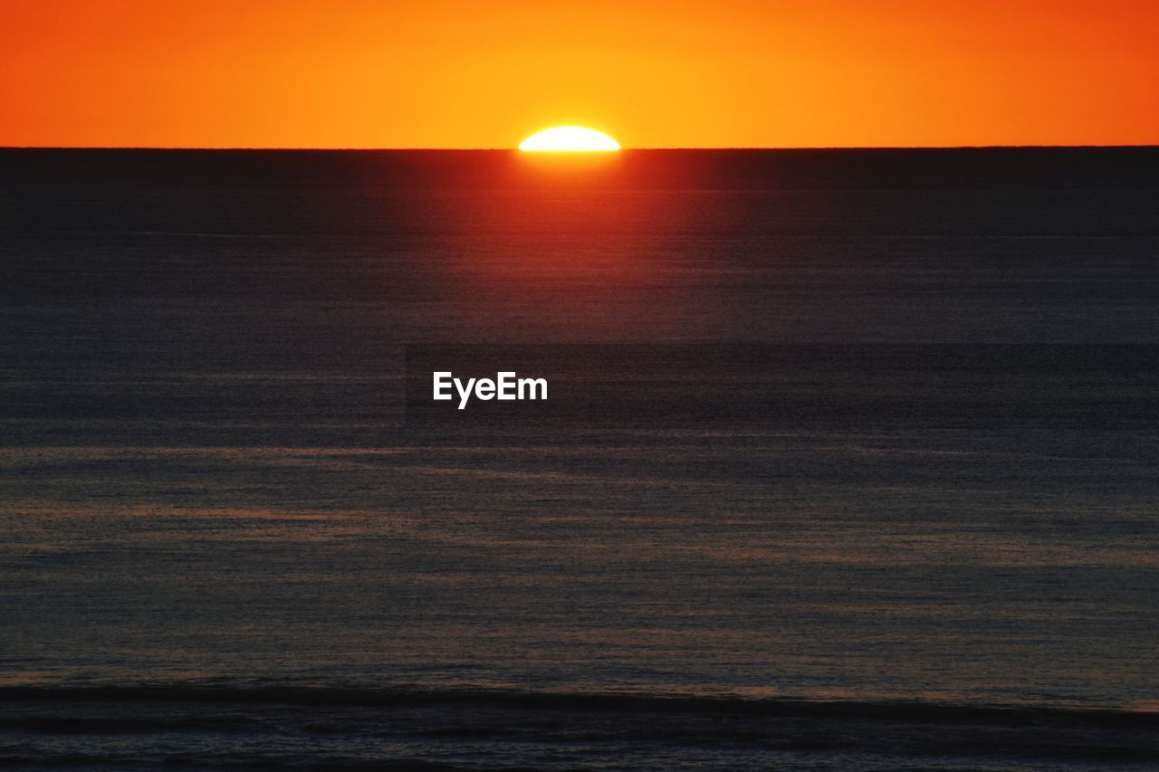 SCENIC VIEW OF SEA AGAINST SKY AT SUNSET