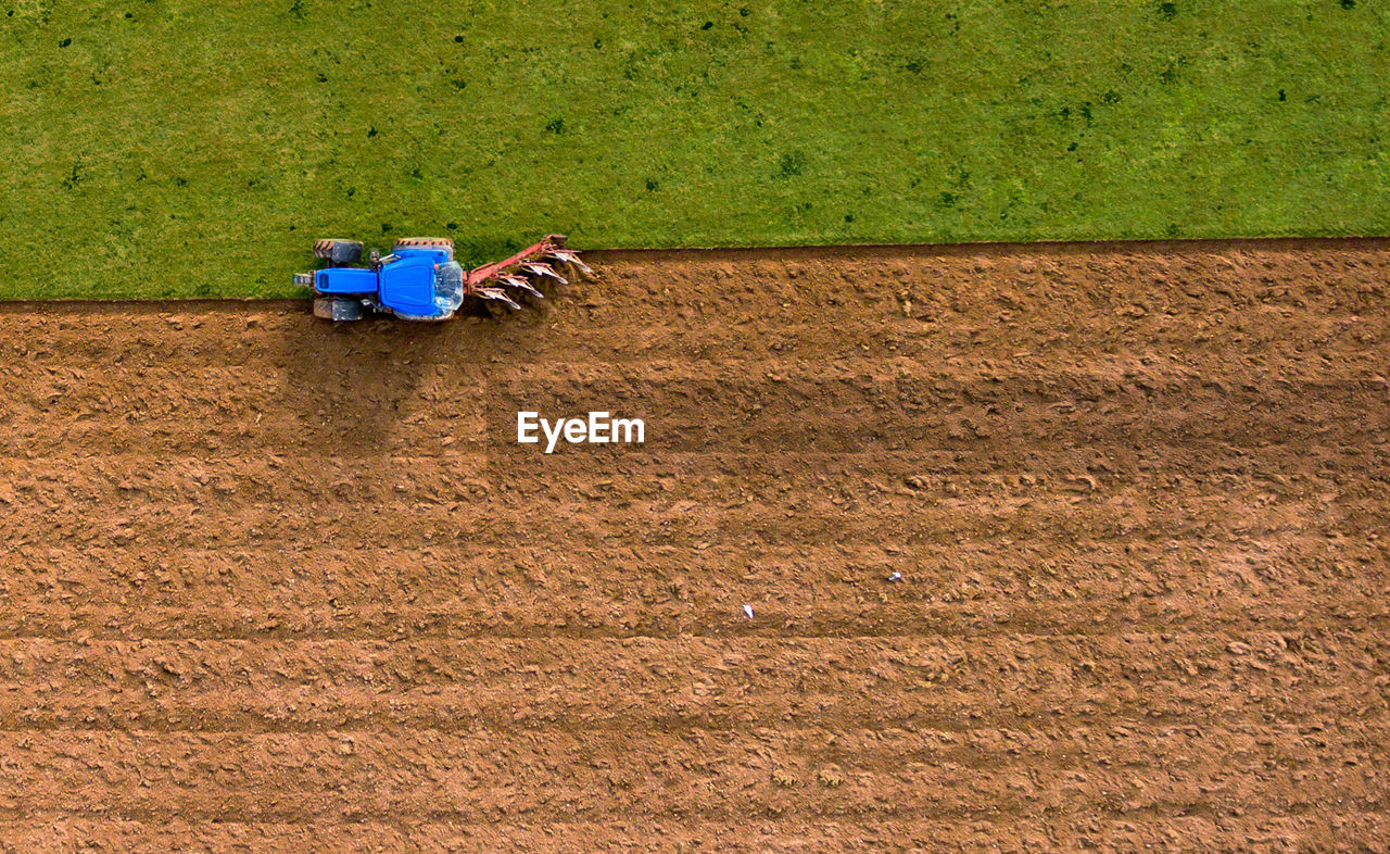 Aerial high angle view of tractor ploughing field