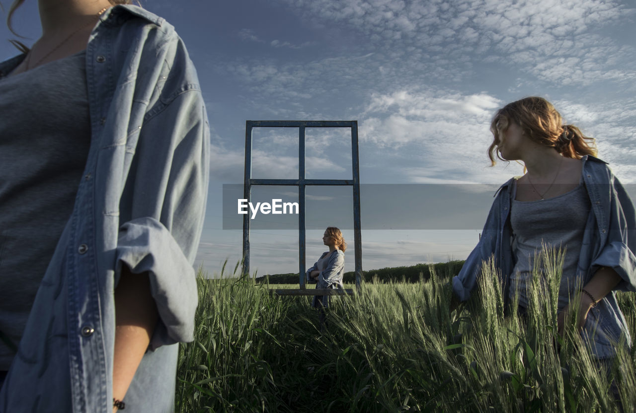 Multiple image of woman standing on field against sky