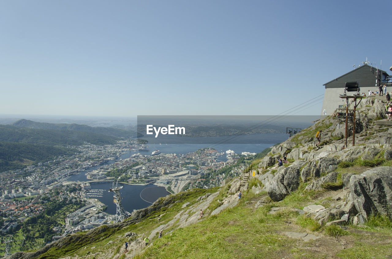 Scenic view of sea and mountains against clear blue sky