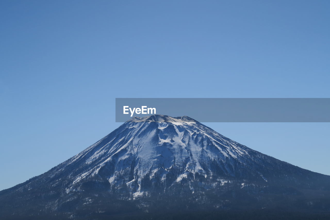 Snowcapped mountain against clear blue sky