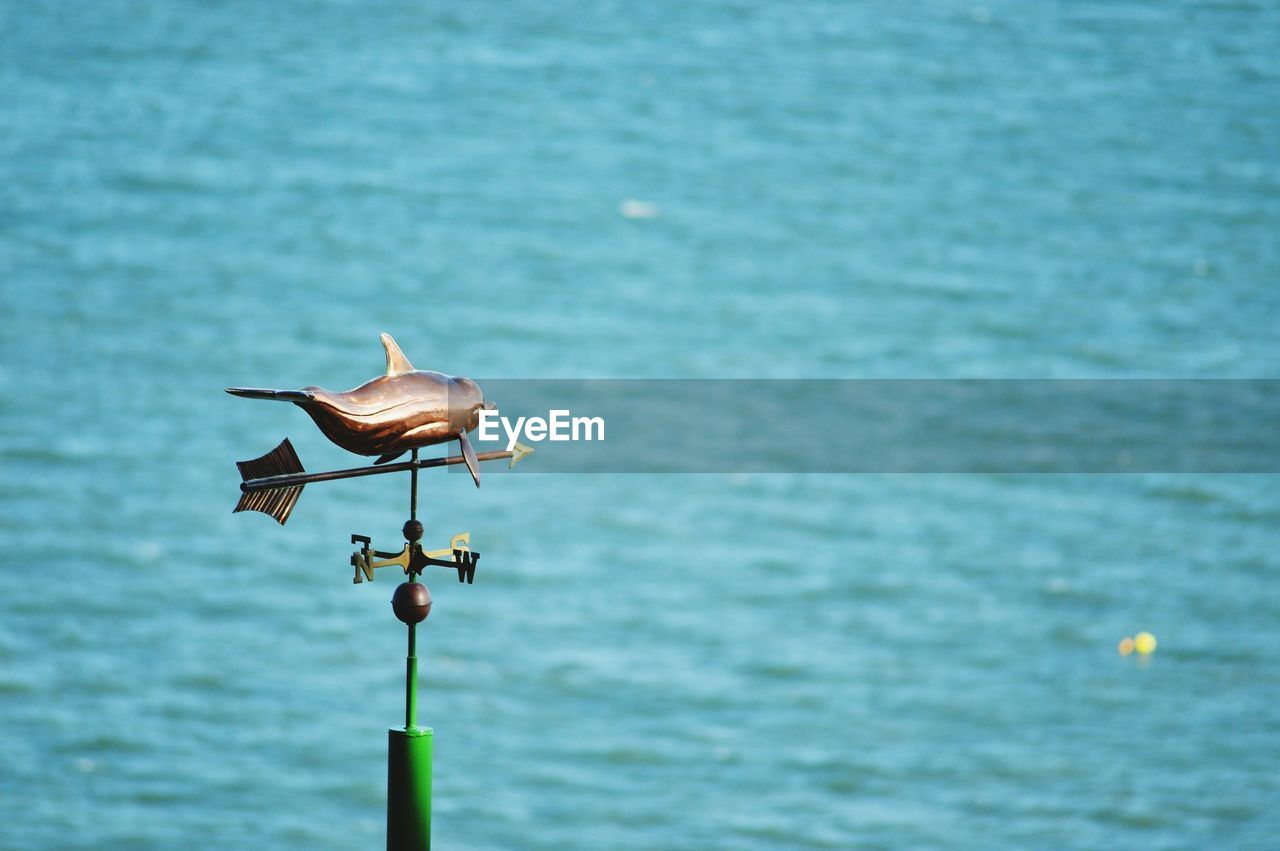 Weather vane against sea