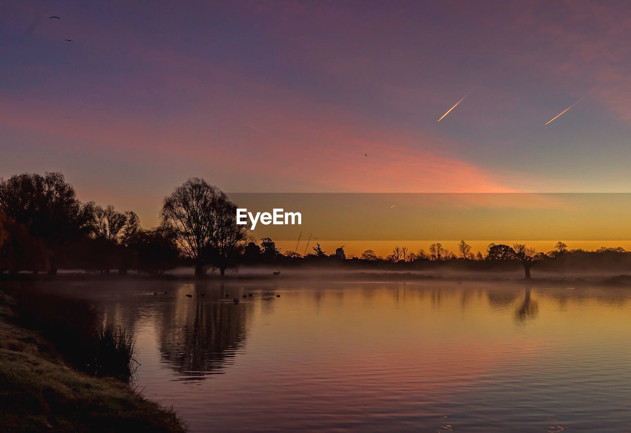 Scenic view of lake against sky during sunset