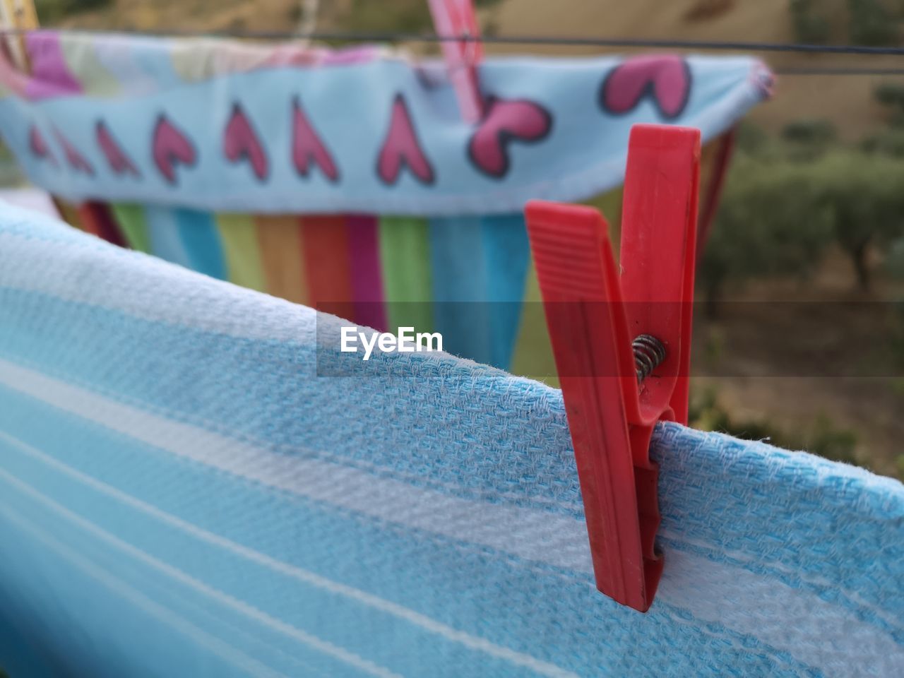 CLOSE-UP OF MULTI COLORED PAPER HANGING ON CLOTHESLINE