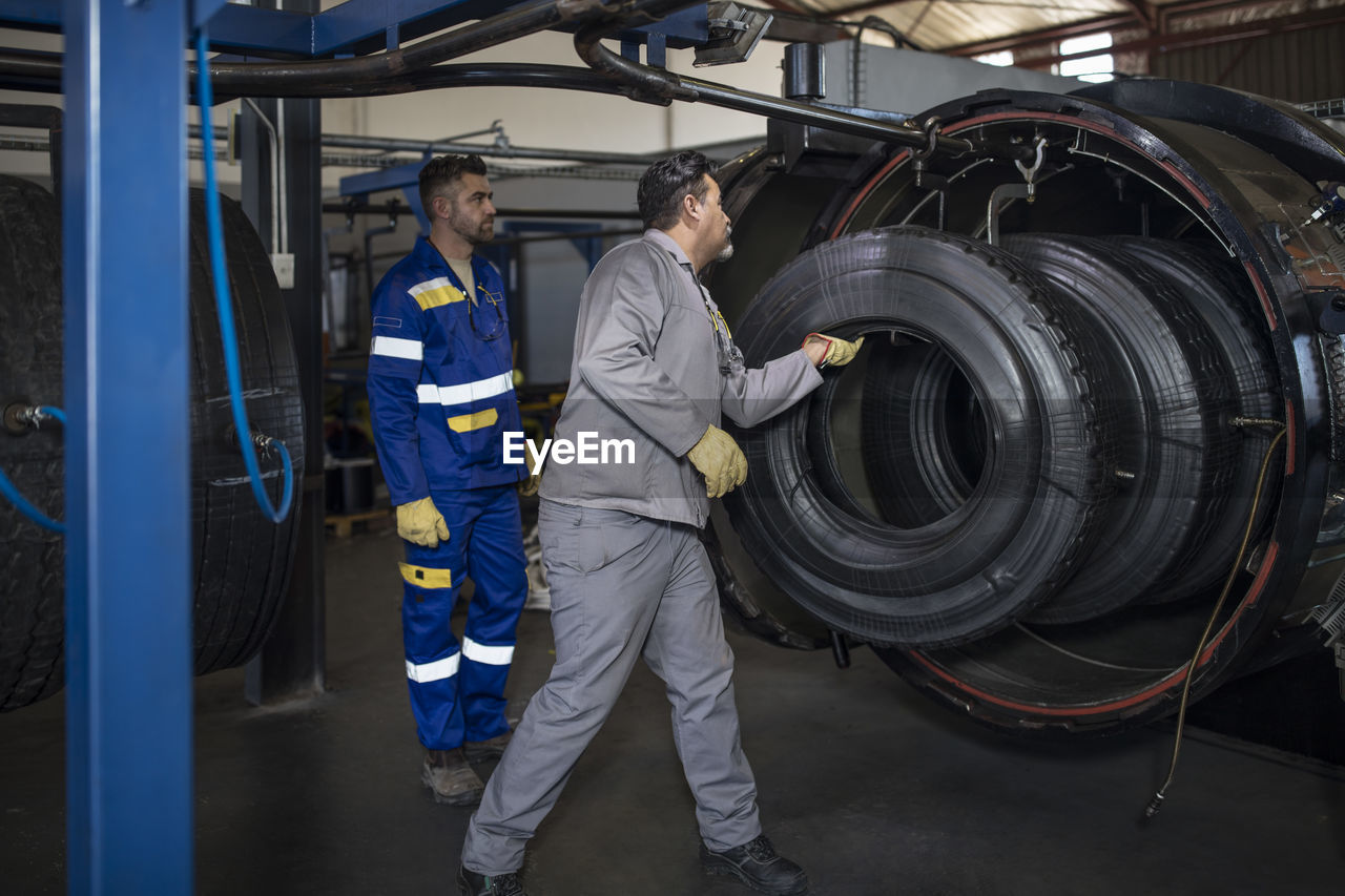 Two tire repairmen working in factory