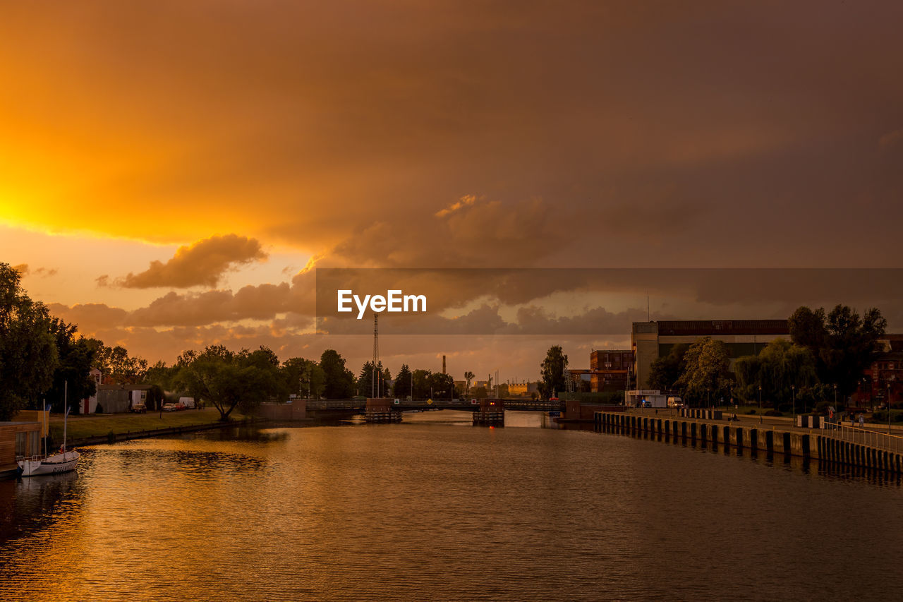 Scenic view of river against sky at sunset