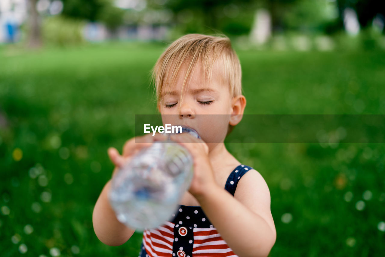 FULL LENGTH OF A BOY HOLDING BUBBLE