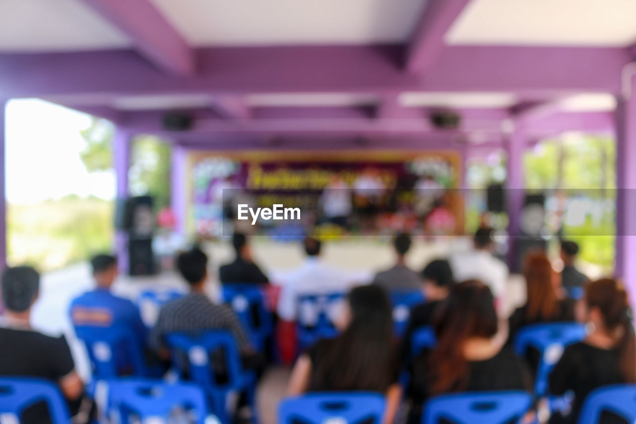 Defocused image of people sitting in meeting