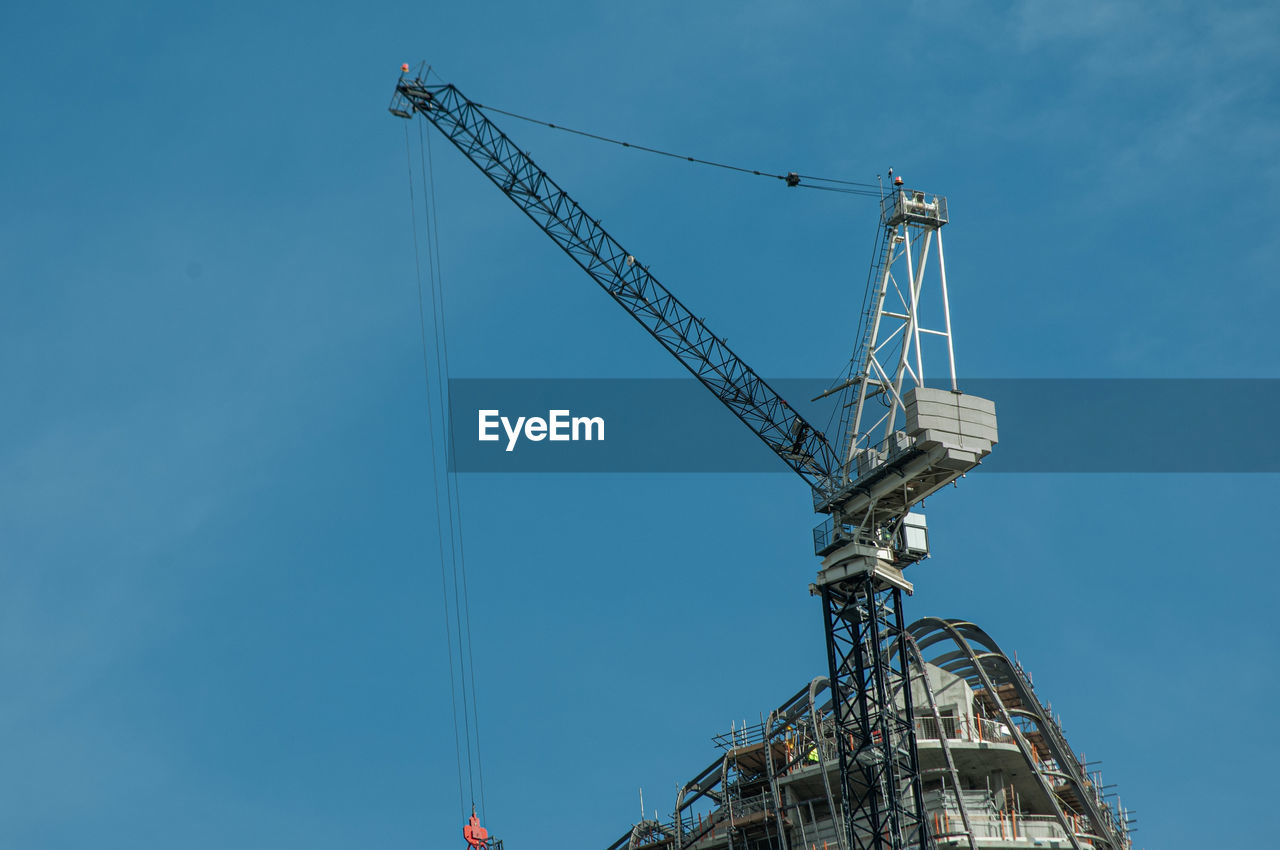 LOW ANGLE VIEW OF CRANES AGAINST SKY