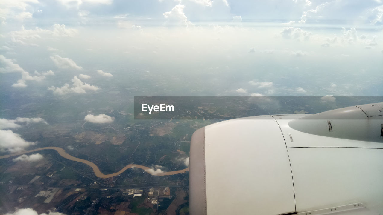 Aerial view of aircraft wing against sky