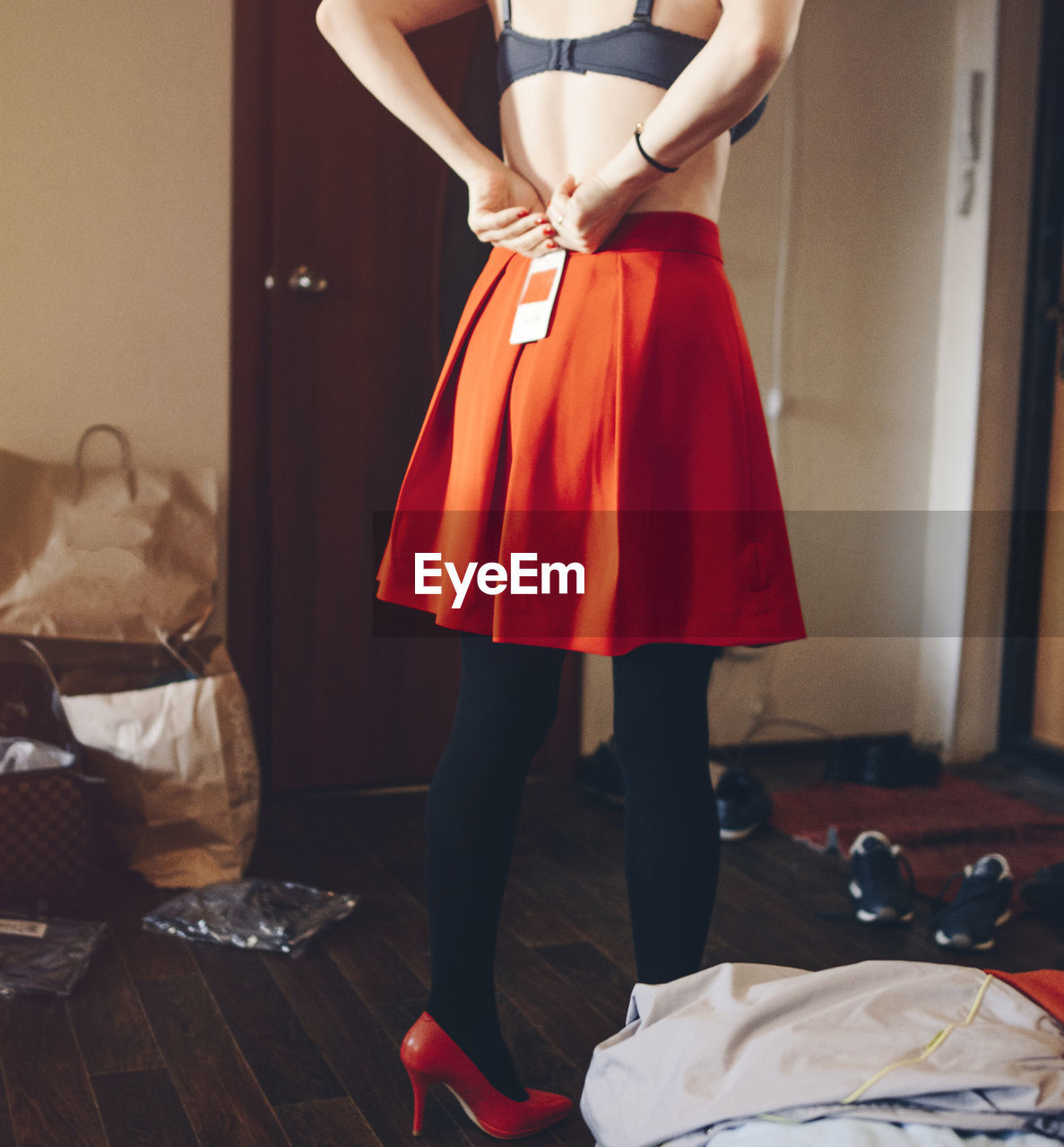 Rear view of woman wearing skirt while standing at home
