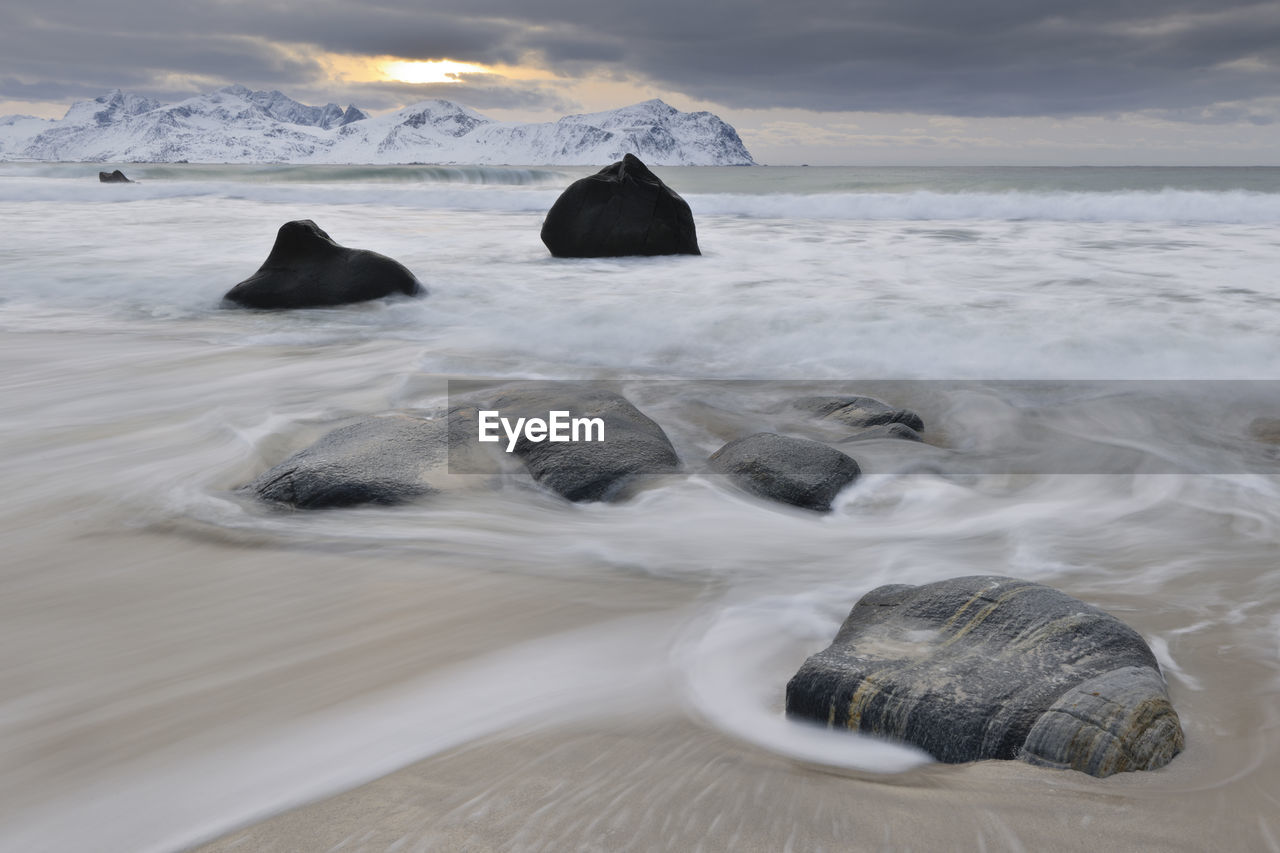 Rocks on sandy beach, lofoten, nordland, norway