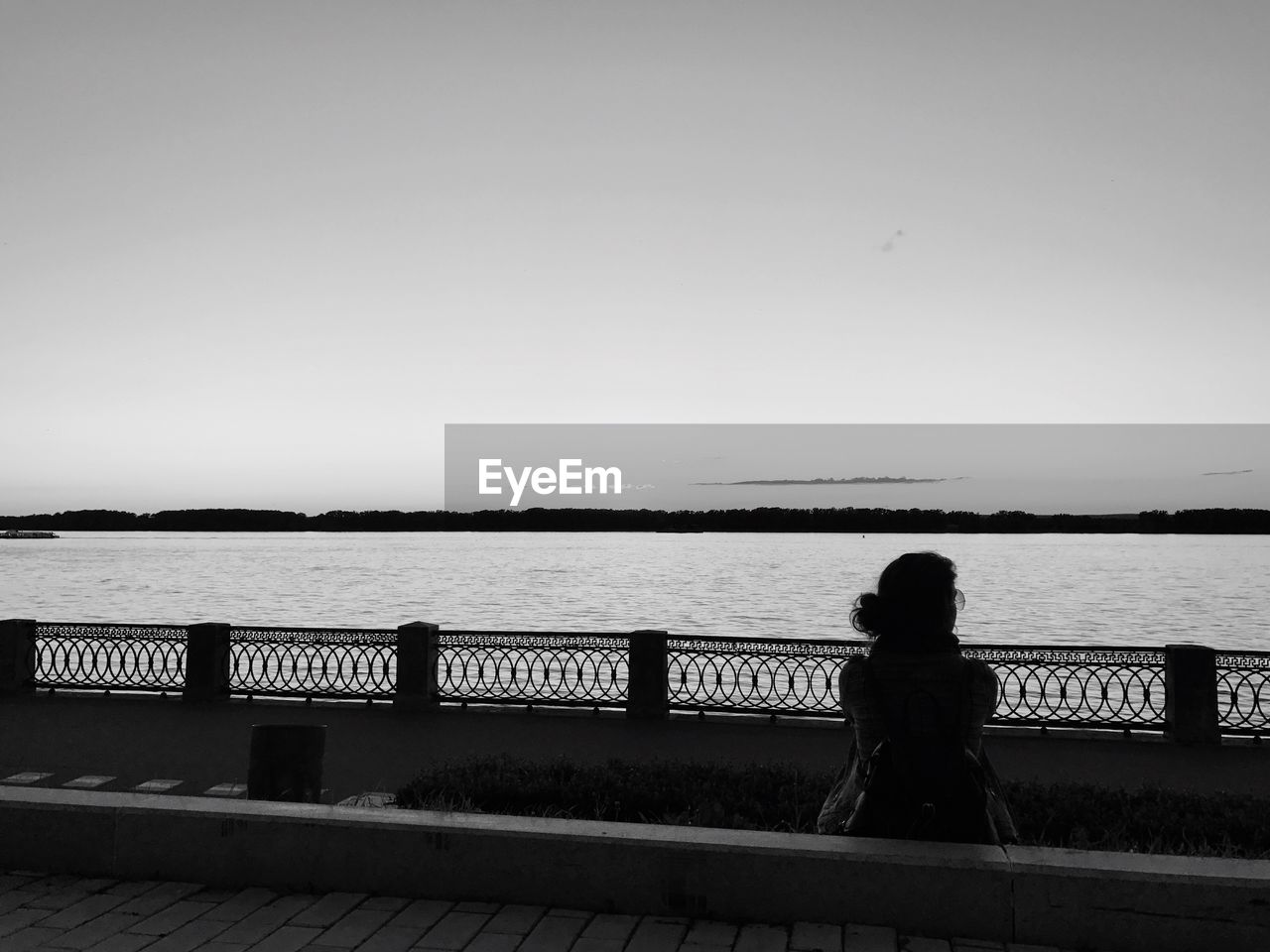 REAR VIEW OF SILHOUETTE WOMAN STANDING BY RAILING AGAINST SEA